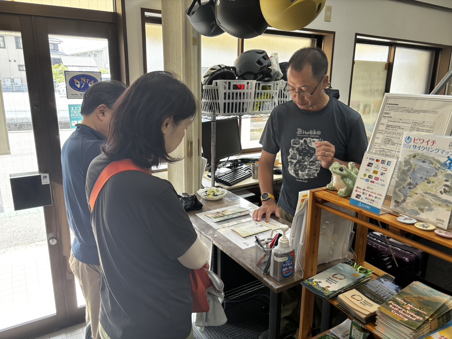店内で地図を広げ、自転車ツアーの案内をする様子